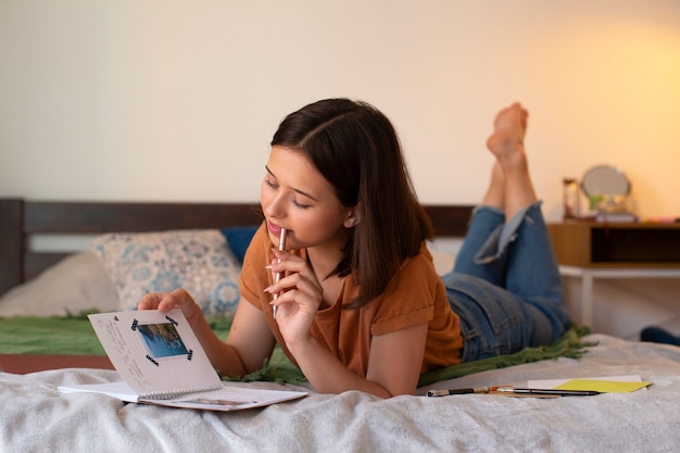 Mujer de tiro completo haciendo un diario creativo