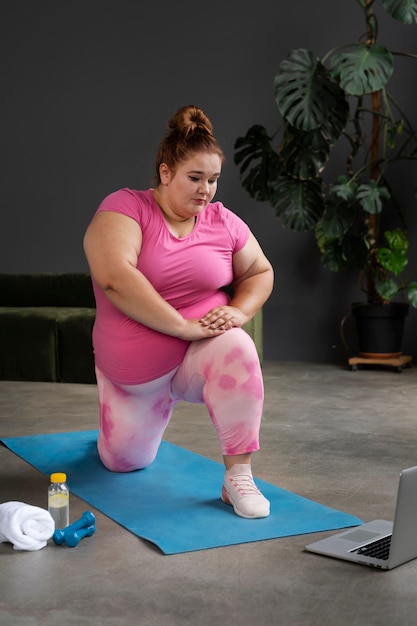 Mujer de tiro completo haciendo ejercicio en el gimnasio