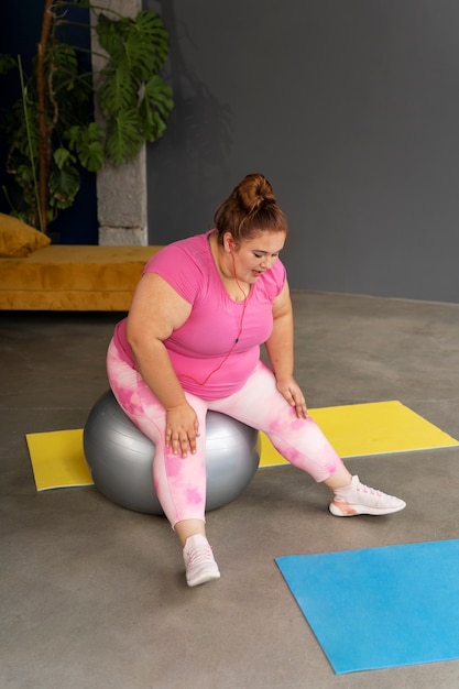 Mujer de tiro completo haciendo ejercicio en el gimnasio