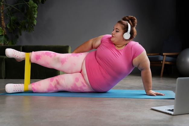 Mujer de tiro completo haciendo ejercicio en el gimnasio