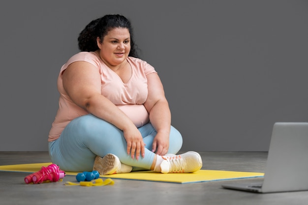 Foto gratuita mujer de tiro completo haciendo ejercicio en el gimnasio