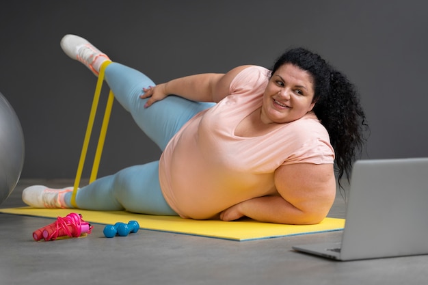 Mujer de tiro completo haciendo ejercicio en el gimnasio