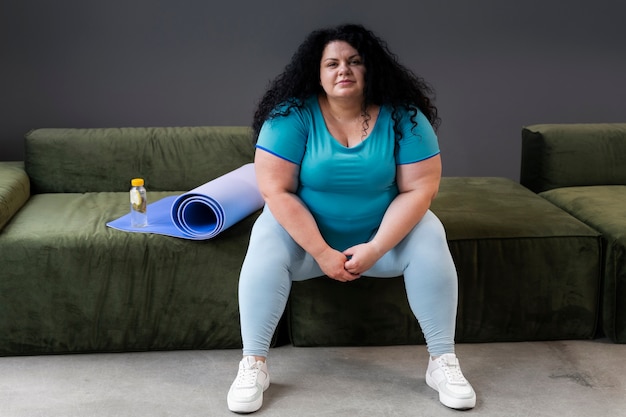 Mujer de tiro completo haciendo ejercicio en el gimnasio