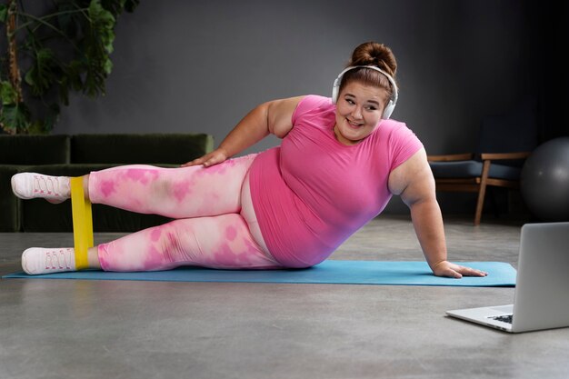 Mujer de tiro completo haciendo ejercicio en el gimnasio