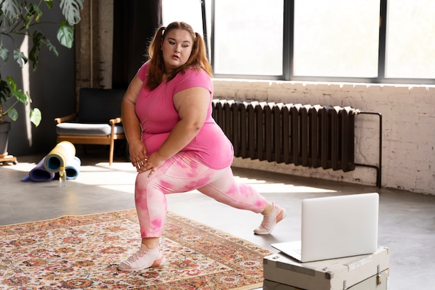 Mujer de tiro completo haciendo ejercicio en el gimnasio