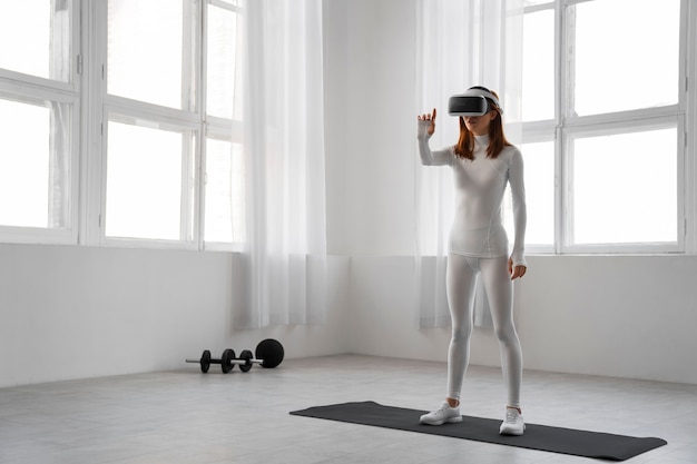 Foto gratuita mujer de tiro completo haciendo fitness con gafas vr