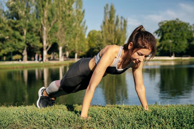 Mujer de tiro completo haciendo flexiones