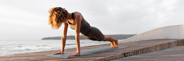 Mujer de tiro completo haciendo plancha fuera