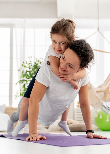 Mujer de tiro completo haciendo plancha con niño