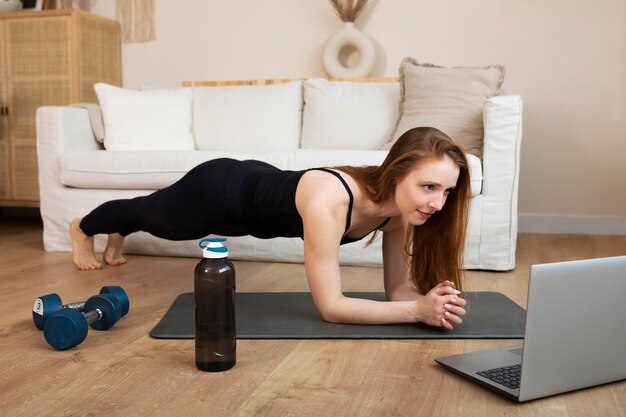 Mujer de tiro completo haciendo plancha