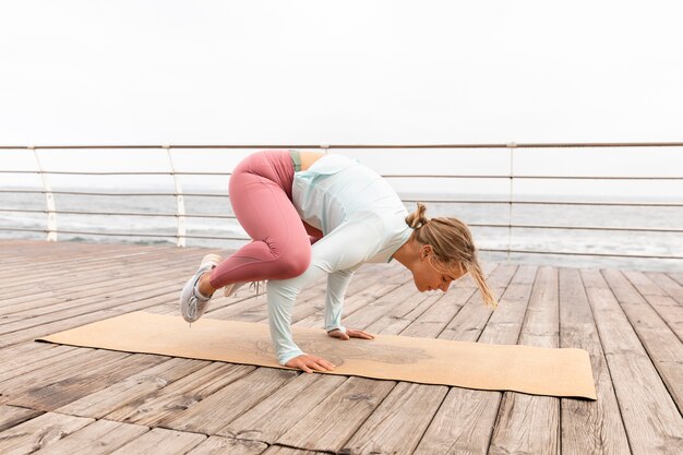 Mujer de tiro completo haciendo pose de yoga