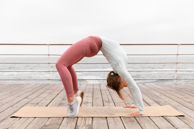 Mujer de tiro completo haciendo pose de yoga