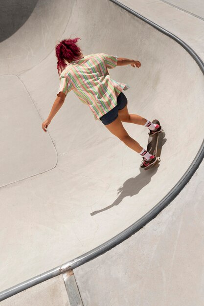 Mujer de tiro completo haciendo trucos en el parque de patinaje