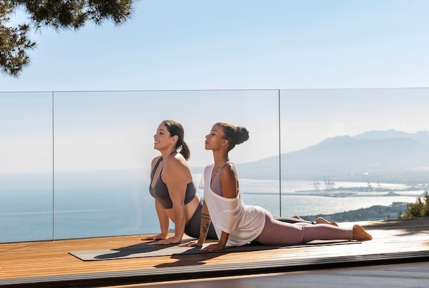 Foto gratuita mujer de tiro completo haciendo yoga con el maestro