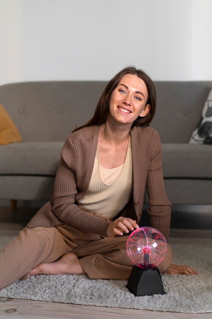 Foto gratuita mujer de tiro completo interactuando con una bola de plasma