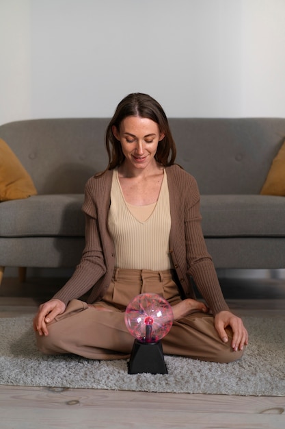 Mujer de tiro completo interactuando con una bola de plasma