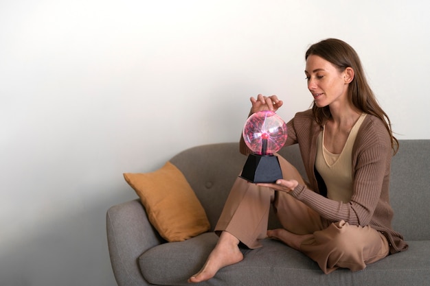 Mujer de tiro completo interactuando con una bola de plasma