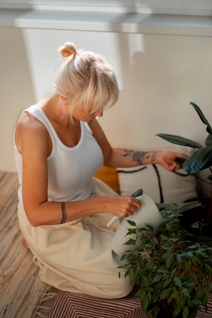 Foto gratuita mujer de tiro completo jardinería en casa