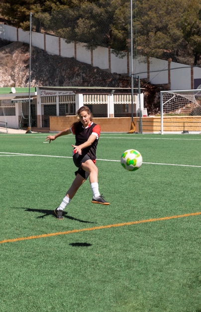 Mujer de tiro completo jugando al fútbol