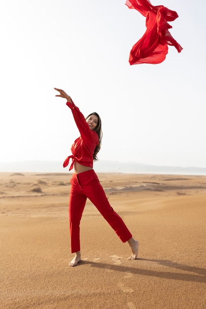 Mujer de tiro completo lanzando bufanda roja