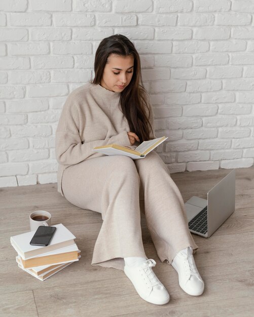 Mujer de tiro completo en la lectura de piso