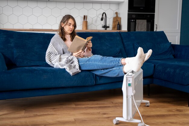 Mujer de tiro completo leyendo en casa