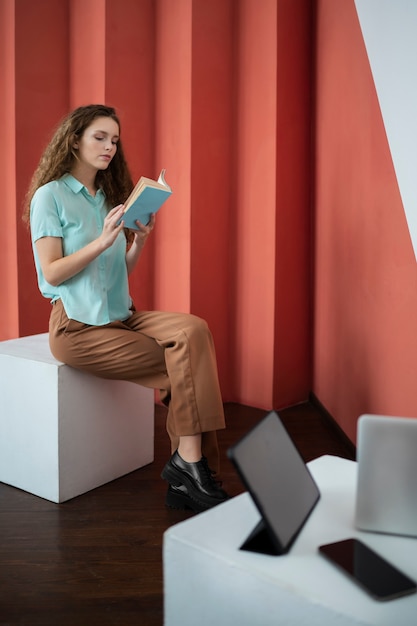 Mujer de tiro completo leyendo en el estudio