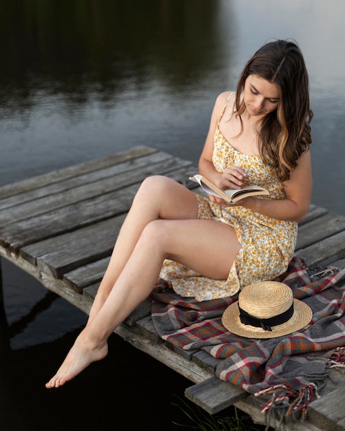 Mujer de tiro completo leyendo fuera