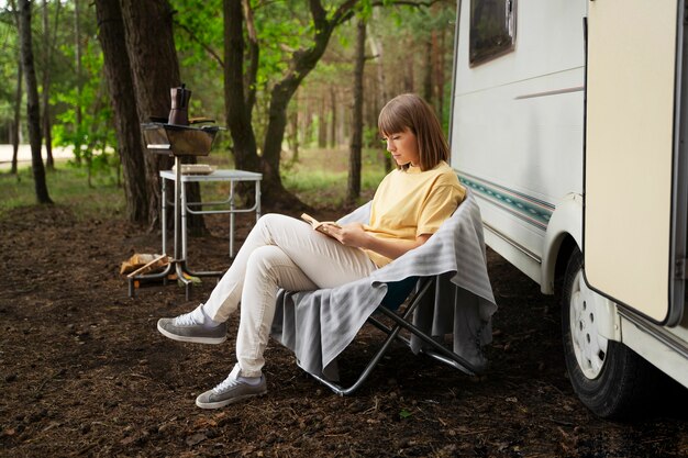 Mujer de tiro completo leyendo en la naturaleza