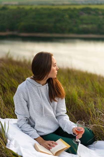 Mujer de tiro completo leyendo en la naturaleza