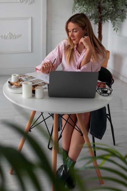 Mujer de tiro completo leyendo tarot con laptop