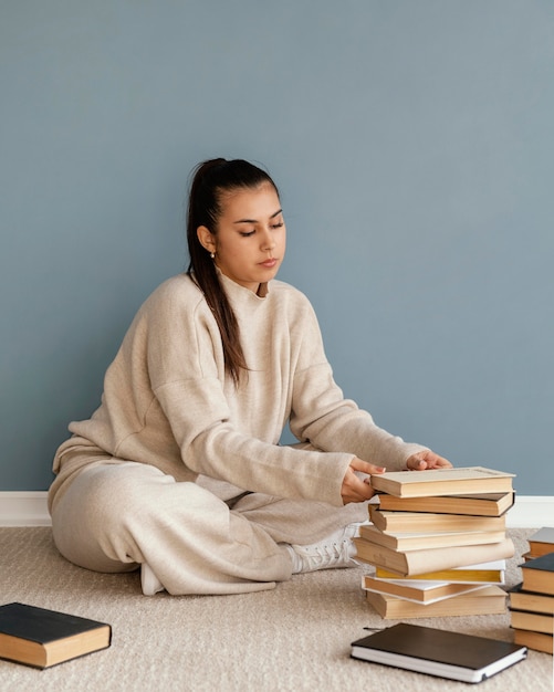 Foto gratuita mujer de tiro completo con libros en el piso