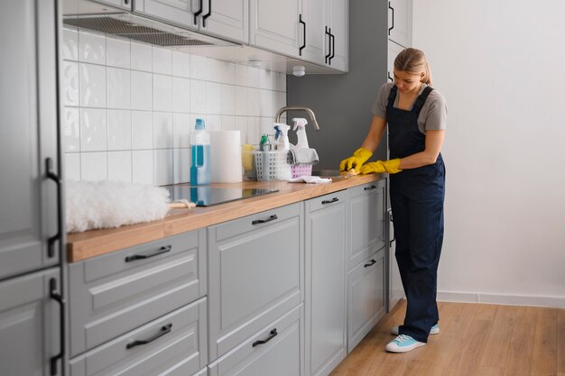 Mujer de tiro completo limpiando casa