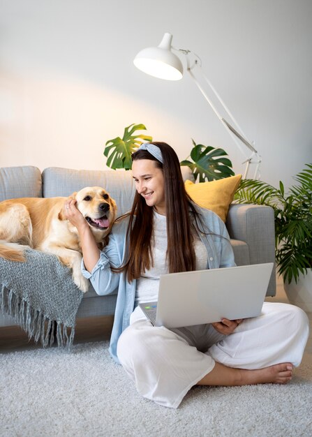 Mujer de tiro completo y lindo perro en casa