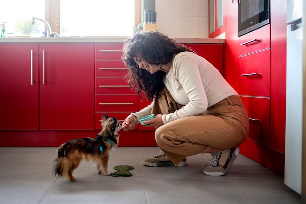 Mujer de tiro completo con lindo perro en casa