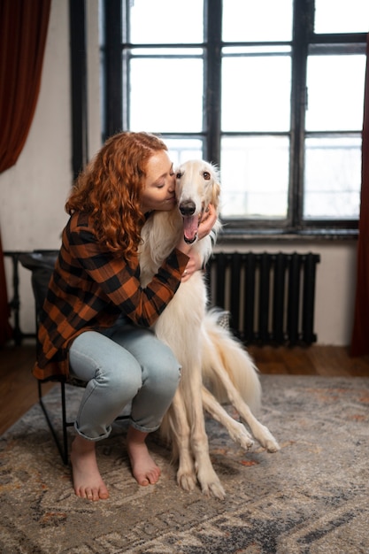 Mujer de tiro completo con lindo perro galgo