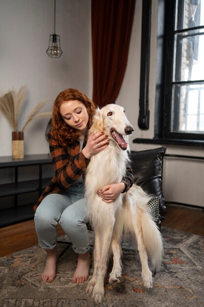 Mujer de tiro completo con lindo perro galgo