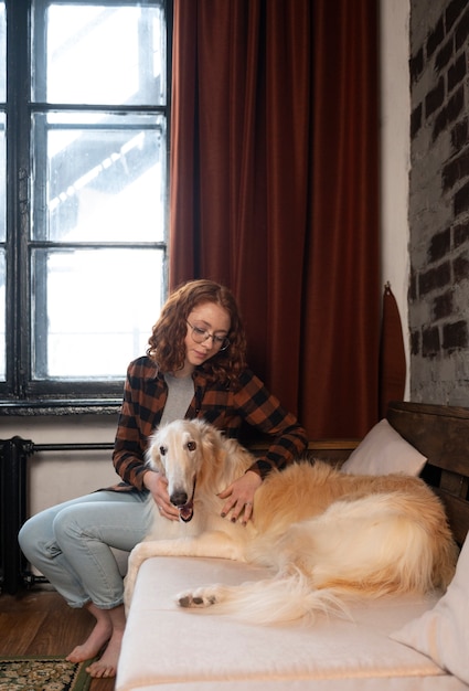 Foto gratuita mujer de tiro completo con lindo perro galgo