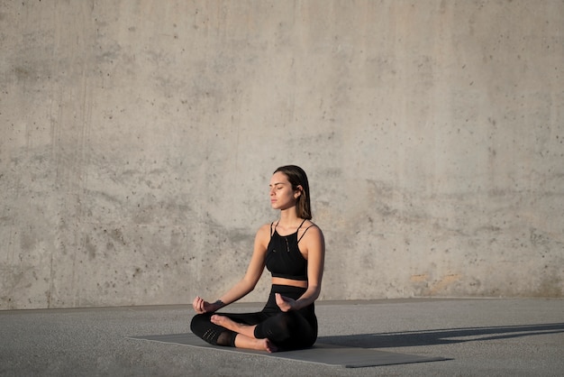 Mujer de tiro completo meditando afuera