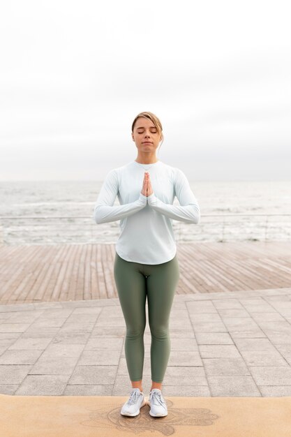 Mujer de tiro completo meditando al aire libre