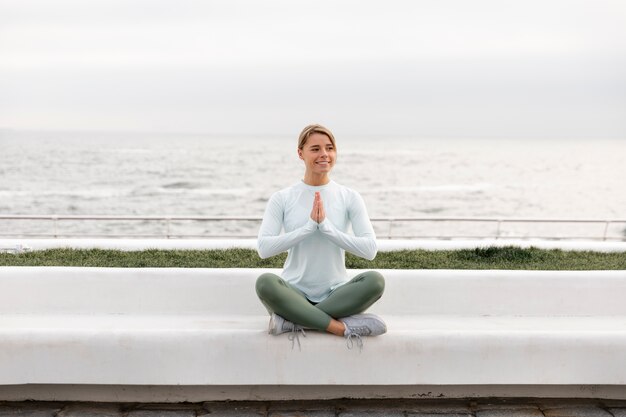 Mujer de tiro completo meditando al aire libre