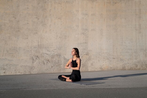 Mujer de tiro completo meditando al aire libre