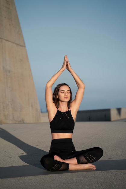 Mujer de tiro completo meditando al aire libre