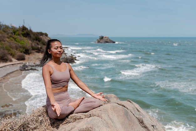 Mujer de tiro completo meditando al aire libre