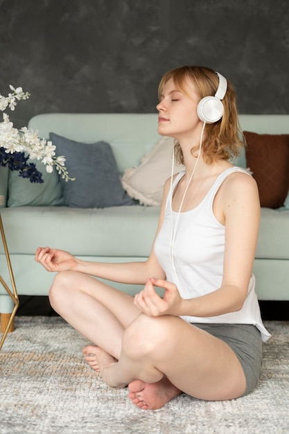 Mujer de tiro completo meditando con auriculares