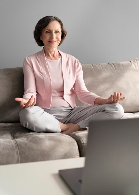 Mujer de tiro completo meditando en casa