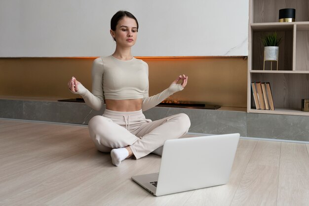 Mujer de tiro completo meditando en casa