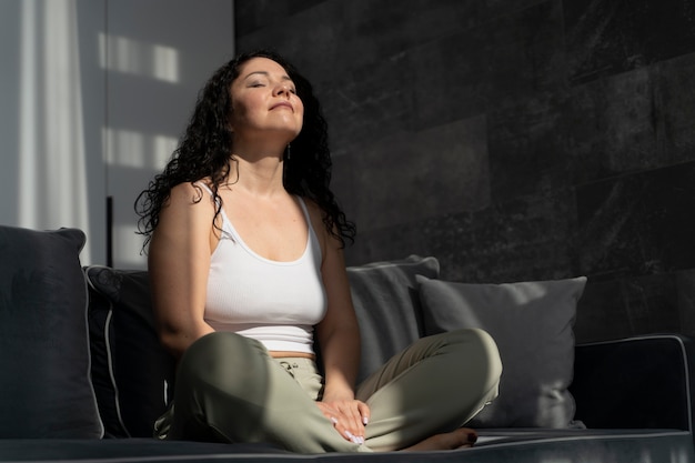 Foto gratuita mujer de tiro completo meditando en casa