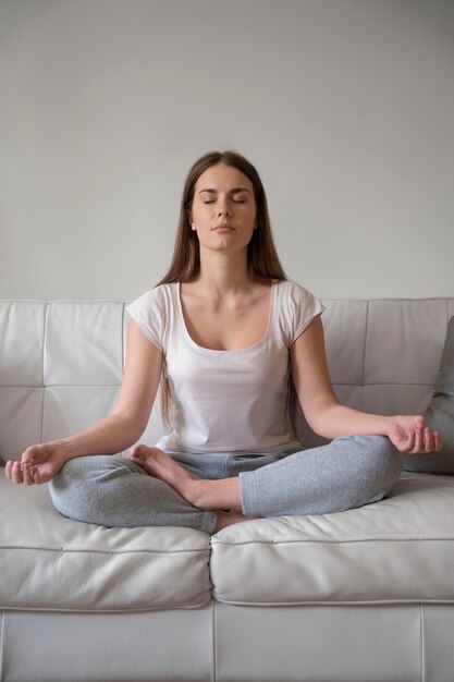 Mujer de tiro completo meditando en casa