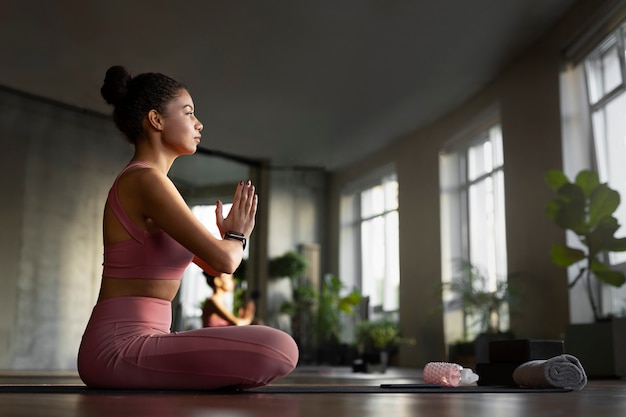 Foto gratuita mujer de tiro completo meditando en interiores